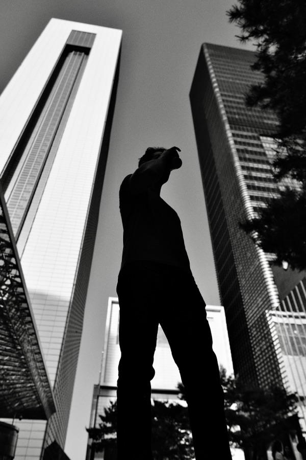 A figure silhouetted between tall buildings