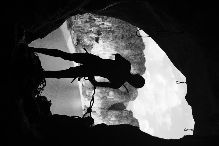 A climber silhouetted in a sea cave